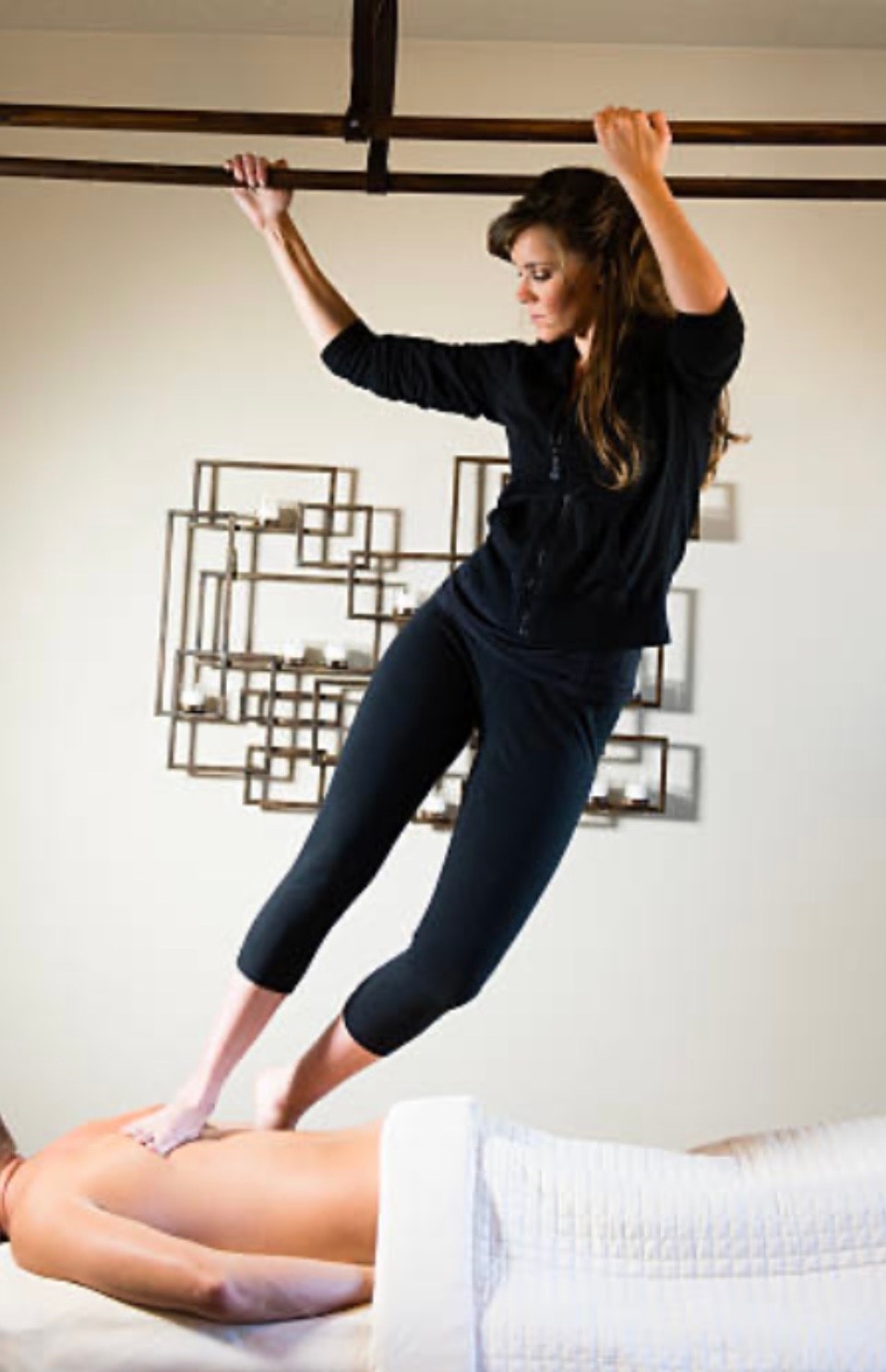 Ashiatsu Oriental Bar Therapy — therapist using overhead bars for deep barefoot massage